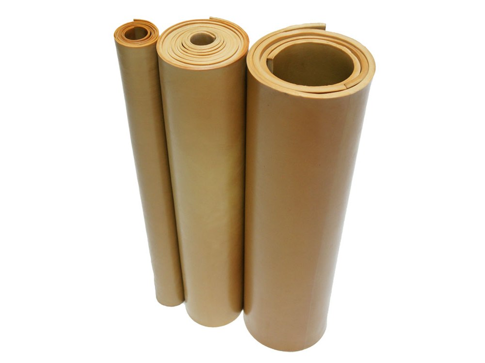 Three rolls of tan pure gum rubber sheet stock, the material boots and sleeves are cut from